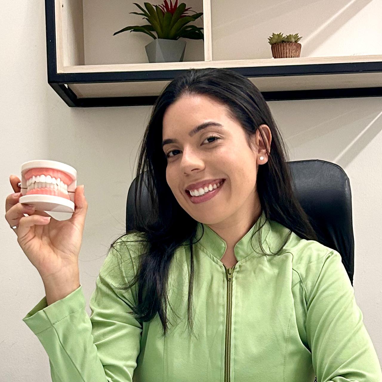 Retrato da Dra. Iara Bernardes sorrindo em um ambiente clínico acolhedor.